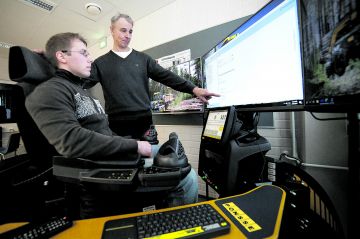 Tiimivastaava Pekka Dahlqvist (oikealla) tutkii Atte Heikkisen kanssa simulaattorin antamaa palautetta harjoitustehtävästä. (Kuvaaja: Mikko Riikilä)