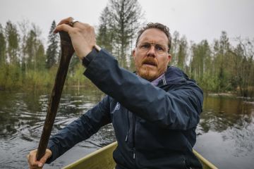 Iijoen kevättulvan aikana Samu Leppänen matkaa Leppämäen yhteismetsän pääkonttorille  veneellä. (Kuvaaja: ANTTI J. LEINONEN)