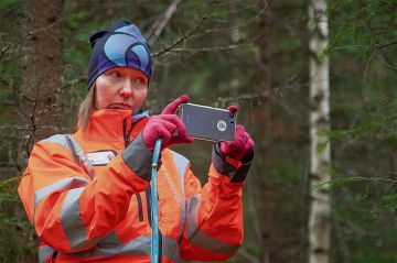 Otson väellä on kiireitä, kun kaikki suunnitelmat valmiiksi ennen lumien tuloa. Asiakasvastaava Mervi Juntunen esittelee suunnittelijan varustusta. Älypuhelin metsänmittausohjelmistoineen korvaa relaskoopin, hypsometrin ja tiedon tallentimet. Kuva Mikko Riikilä.