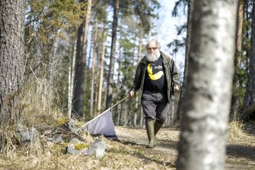 Heikki Henttonen pyydystää punkkeja metsäteiden varsilta Kuhmoisissa. (Kuvaaja: Seppo Samuli)