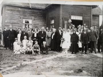 Juhlaväki on kokoontunut talon eteen Suonenjoen Metsälässä 1920-luvun lopulla otetussa kuvassa. Kuvassa vasemmalla näkyvän lapsijoukon keskellä etummaisena istuva pikkupoika on Sirpa Hyytiäisen isä Esko Markkanen. (Kuvaaja: Sirpa Hyytiäisen kotialbumi)